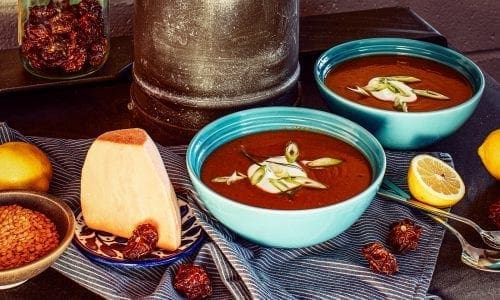 Fiery Red Lentil Yam Soup shown with chillis and yoghurt